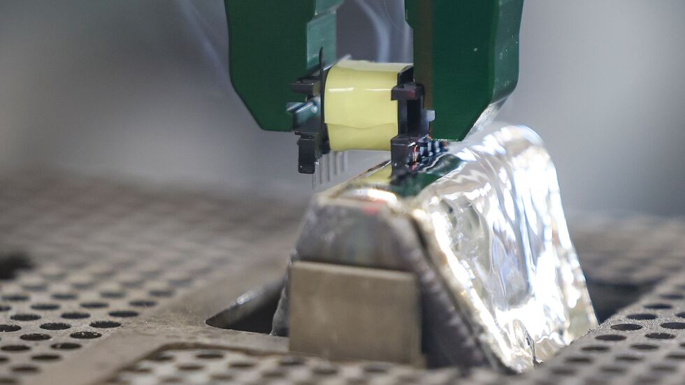 Per Roboter-Greifarm werden die Pins einer Spule in ein 400 Grad heißes Zinnbad getaucht.