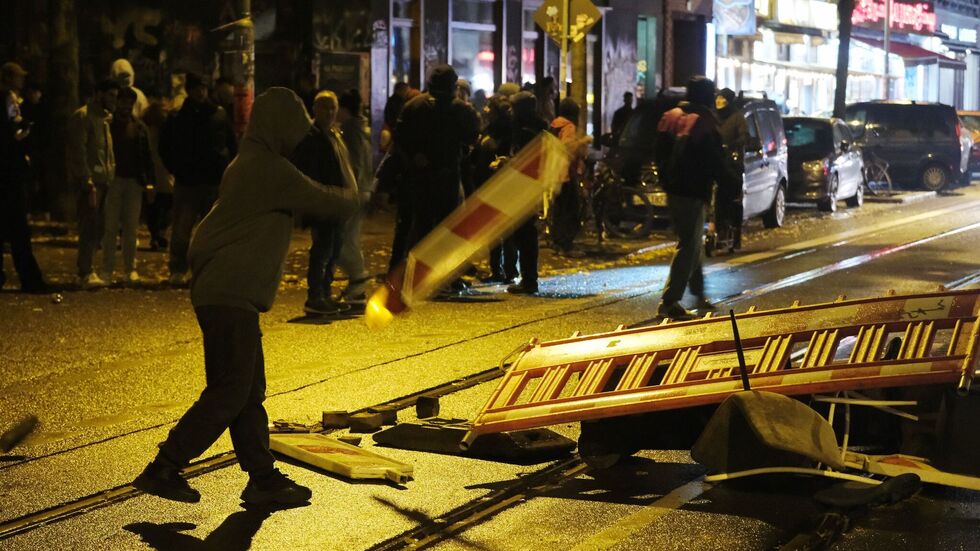 Vermummte errichten Barrikaden.