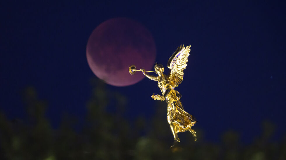 Der Mond geht am Abend zu einer totalen Mondfinsternis hinter dem Engel «Fama» auf der Kunstakademie auf