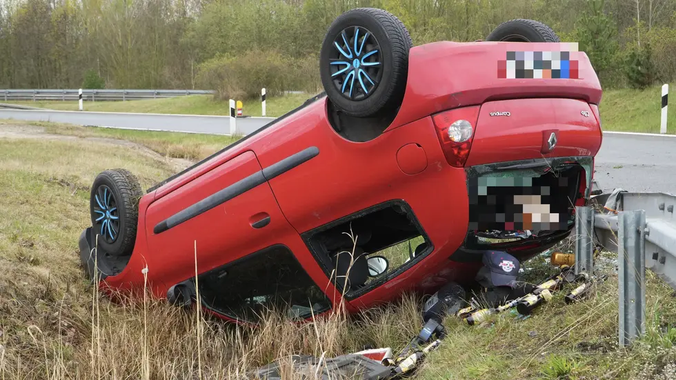 Der rote Renault Clio liegt auf dem Dach, aus dem Inneren sind unter anderem mehrere Flaschen Radler gefallen.