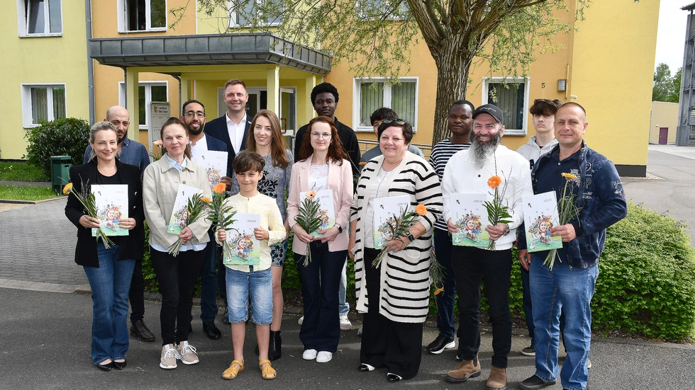 Landrat Marcel Schmidt (hinten 3.v.l.) mit den neuen  Staatsbürgern beim Gruppenfoto vor dem Ordnungsamt in Herzberg