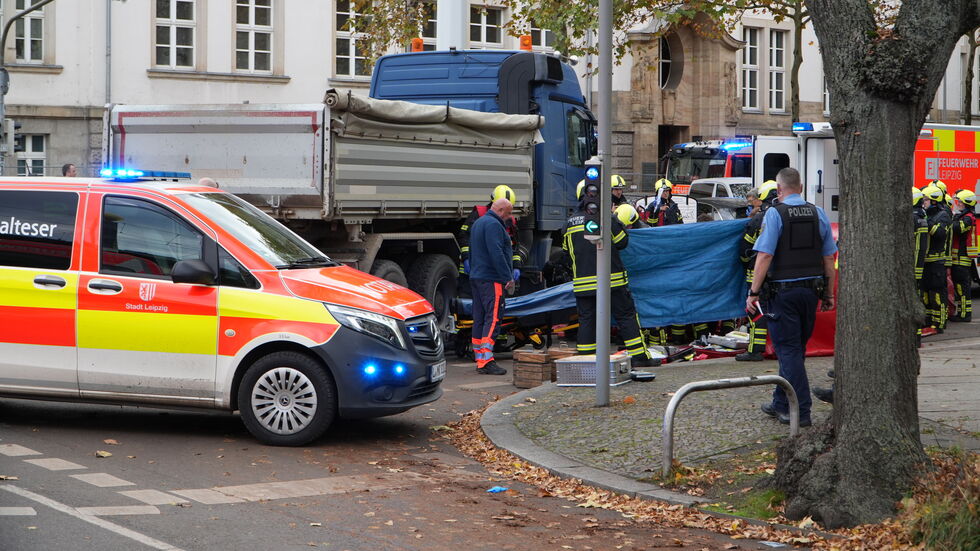 Die schwer verletzte Frau wird von Rettungskräften behandelt - die Szene wird mit einer Plane vor Schaulustigen abgeschirmt Die schwer verletzte Frau wird von Rettungskräften behandelt - die Szene wird mit einer Plane vor Schaulustigen abgeschirmt
