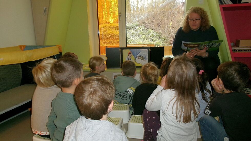 Aufmerksam hören die Kinder Vorlesepatin Manuela Hache zu. 
