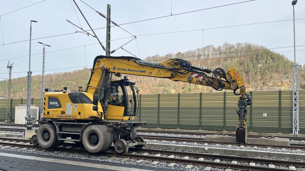 Schienenfahrzeuge füllen das Schotterbett zwischen den neu verlegten Gleisen auf