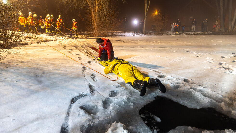 Kalte Angelegenheit: Per Steckleiter und Spineboard wird das vermeintliche Opfer aus dem Wasser geholt.