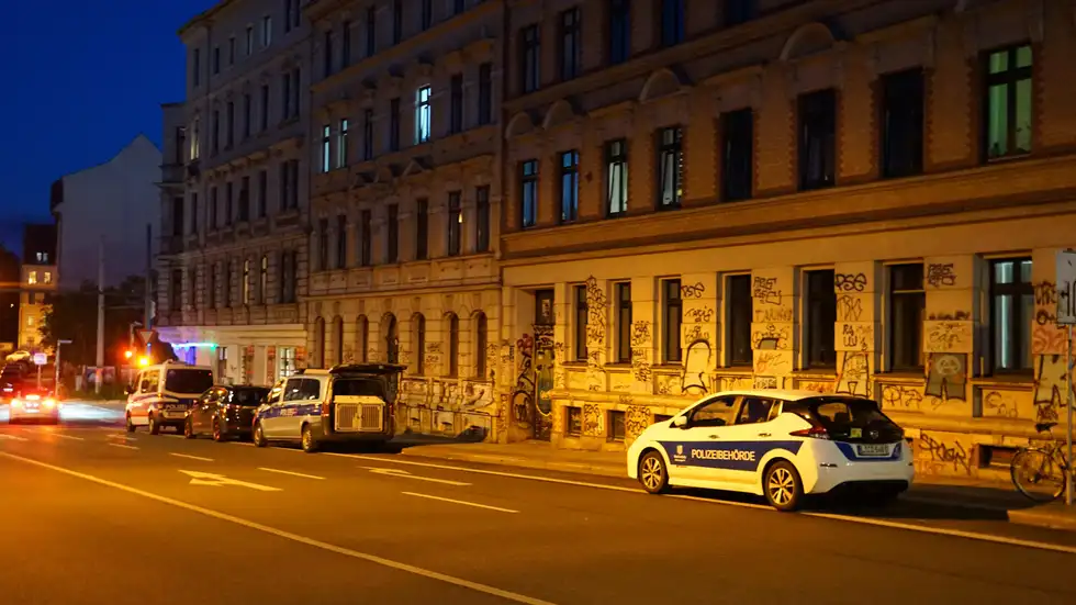 Polizeikräfte stehen vor der Spielothek an der Hermann‑Liebmann‑Straße. In den Räumen läuft die Durchsuchung.