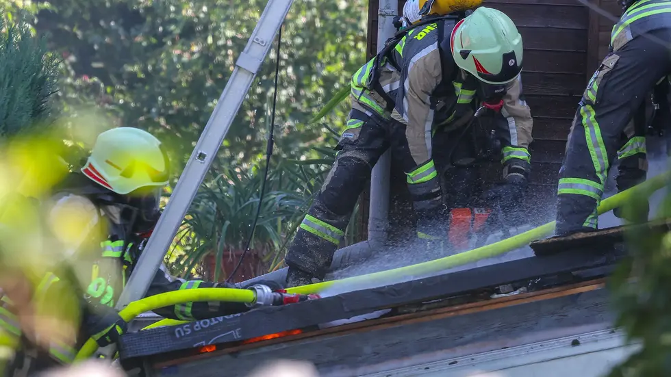 Hier sägt die Feuerwehr das Dach des Hauses auf. 
