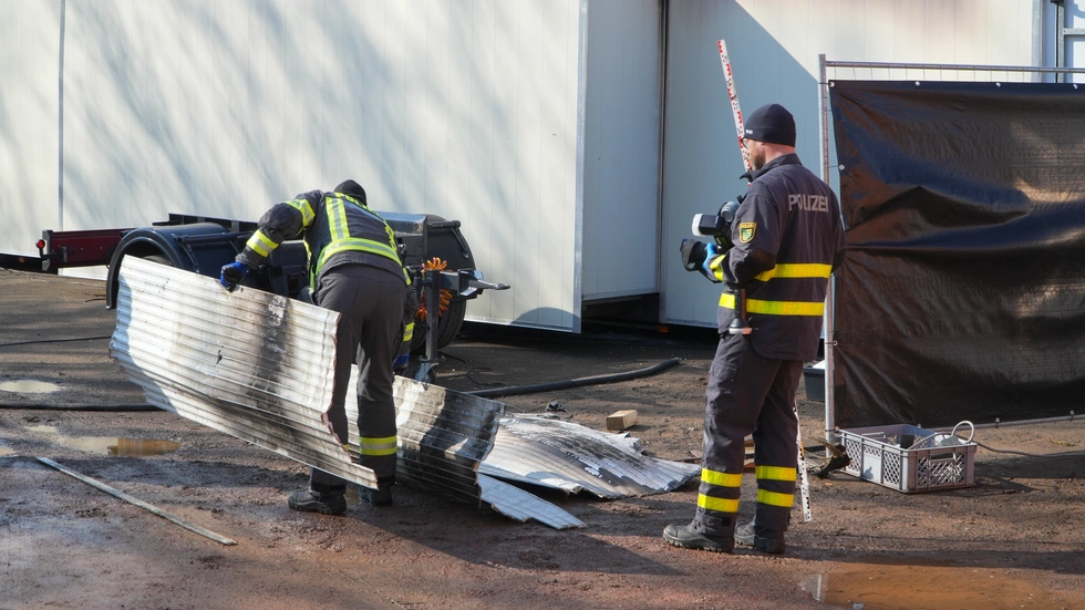 Polizisten untersuchen den Brandort.