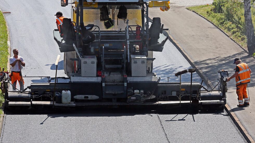 Bauarbeiter beim Asphaltieren einer Straße (Symbolbild).