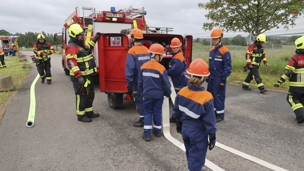 Die Jugendfeuerwehr stehen am Einsatzfahrzeug und rollen Schläuche aus. Die Jugendfeuerwehr stehen am Einsatzfahrzeug und rollen Schläuche aus.