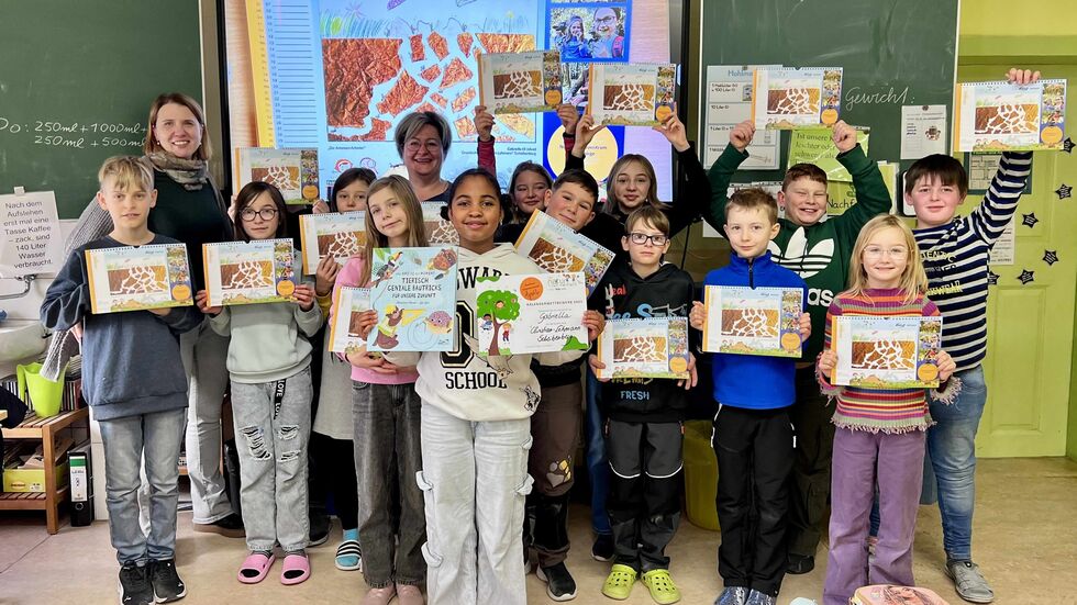 Martina Flade (enviaM/MITGAS Bildungsprojekte) mit Gewinnerin Gabriella (9 Jahre/vorn in der Bildmitte) sowie den Mitschülern (Klasse 4) und Klassenlehrerin Frau Baumann (links im Bild) von der Grundschule "Christian Lehmann“ Scheibenberg.