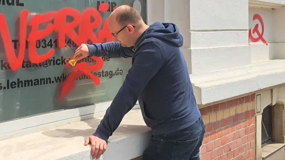 Der Leipziger Landtagsabgeordnete Rick Ulbricht beim Abkratzen der Schmierereien. Der Leipziger Landtagsabgeordnete Rick Ulbricht beim Abkratzen der Schmierereien.