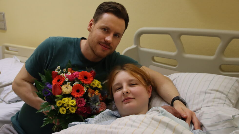 Anastasia mit ihren Eltern Maria Pausch und Toni Fröhlich. Ihr Köpfchen schaut rechts aus der Decke heraus.