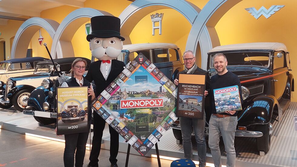 Florian Freitag (rechts im Bild) bei der Vorstellung des Sachsen-Monopoly. Daneben Annett Lang vom August-Horch-Museum (links) und Klaus Baumgärtel (2.v.l.) von KSI Kältetechnik - der Vertreter der Stadt Reichenbach auf dem Spielfeld.