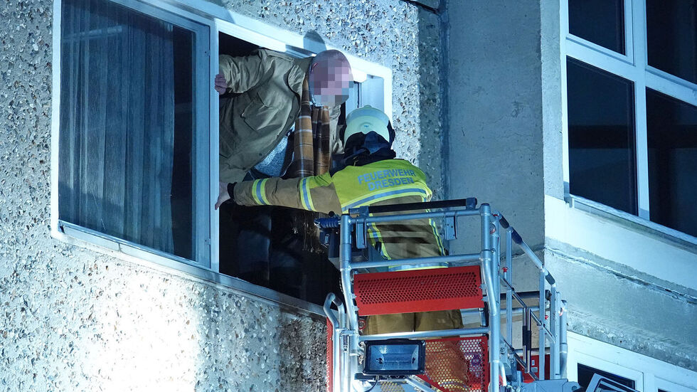Ein Mann wird aus dem verrauchten Haus gerettet.