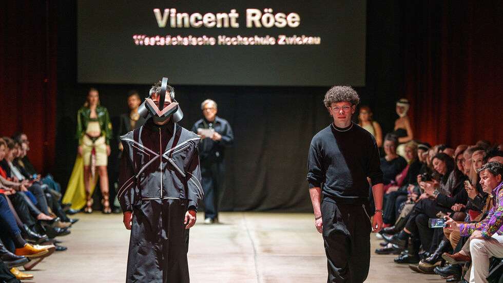 Ein Model (li.) trägt das preisgekrönte Designerstück auf dem Laufsteg - rechts daneben Vincent Röse. Ein Model (li.) trägt das preisgekrönte Designerstück auf dem Laufsteg - rechts daneben Vincent Röse.