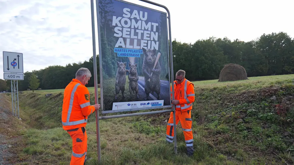 Zwei Straßenwärter stellen ein Plakat an der B 173 auf. Zwei Straßenwärter stellen ein Plakat an der B 173 auf.