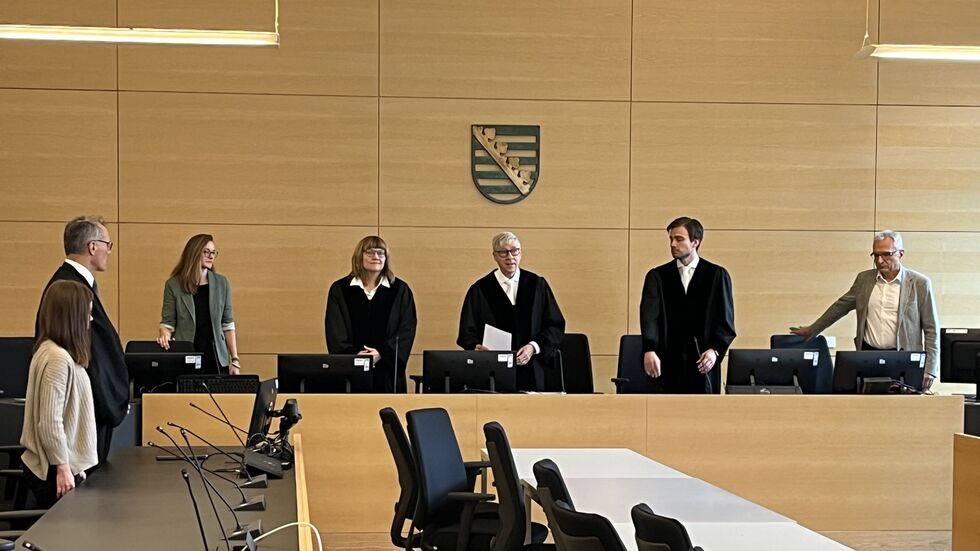 Lisa (li.) und ihr Anwalt erheben sich zur Urteilsverkündung am Landgericht Dresden