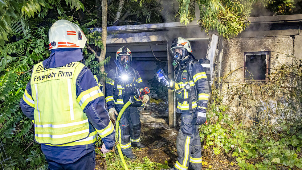 Feuerwehrleute löschen den Brand in dem früheren Garagenkomplex