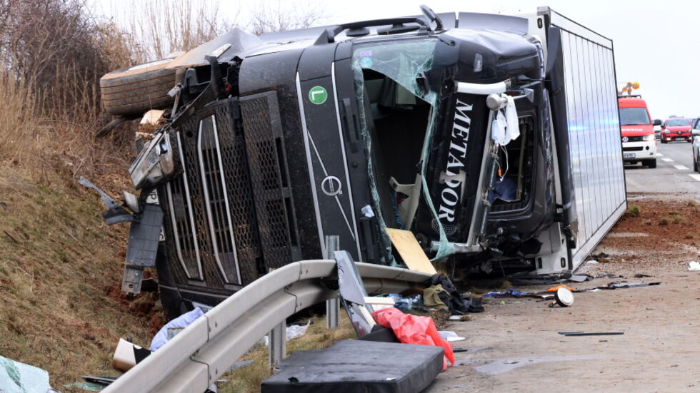 Der verunglückte Laster liegt auf der Seite am Randstreifen.